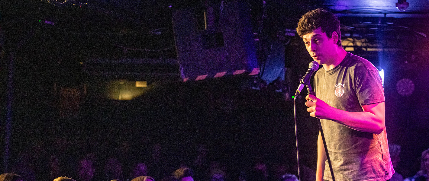 Matt Richardson, a white man with short brown hair, talking into a microphone on stage.